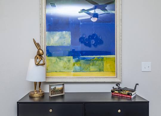 Console table with abstract painting and decorative accents at Sienna at Westover Hills Apartments, San Antonio, TX