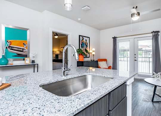 Kitchen island with granite countertop and bar seating at Sienna at Westover Hills Apartments, San Antonio, TX