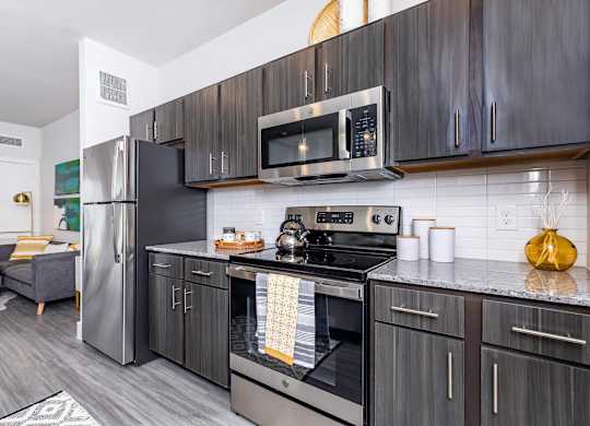 Modern kitchen with dark wood cabinetry and appliances at Sienna at Westover Hills Apartments, San Antonio, 78253
