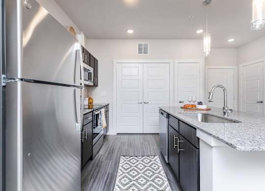 Modern galley kitchen with stainless steel appliances at Sienna at Westover Hills Apartments, San Antonio