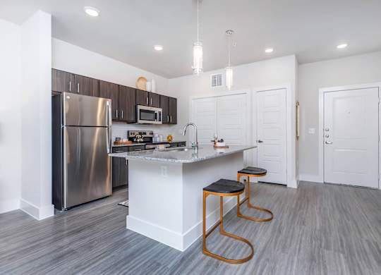 Open concept kitchen with island and bar stools at Sienna at Westover Hills Apartments, Texas