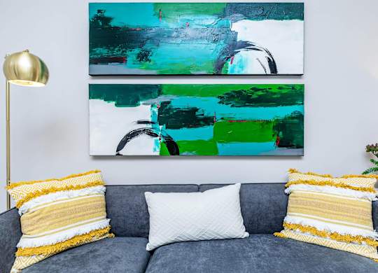 Gray sofa with yellow accent pillows and artwork at Sienna at Westover Hills Apartments, San Antonio