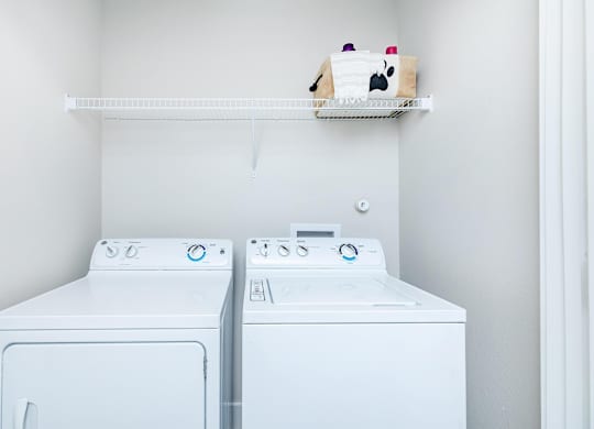 Laundry room with washer dryer and storage shelf at Sienna at Westover Hills Apartments, San Antonio, TX 78253