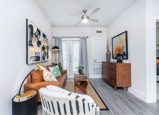 Living room entry with tan sofa and ceiling fan at Sienna at Westover Hills Apartments, Texas