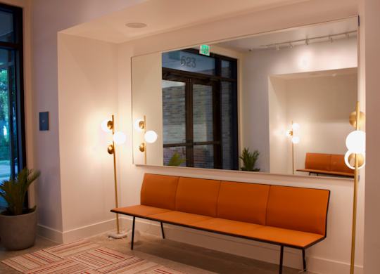 Modern lobby seating area with orange bench at THE'68 Apartments, San Antonio, TX