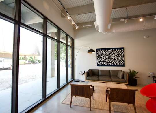 Modern lounge area with floortoceiling windows at THE'68 Apartments, San Antonio, Texas