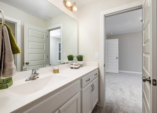 a bathroom with white cabinets and a large mirror
