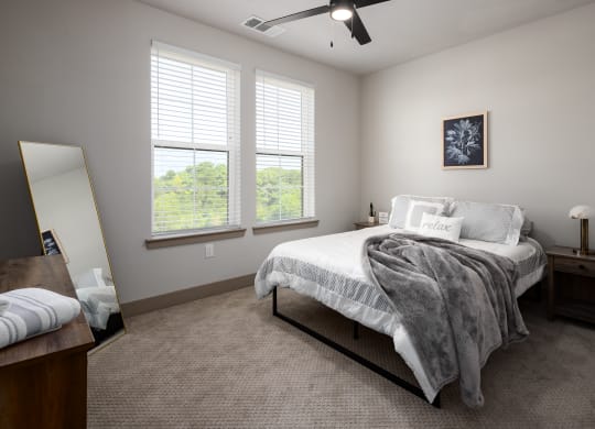 a bedroom with a bed and two windowsat Abberly Foundry Apartment Homes, Nashville, TN, 37206