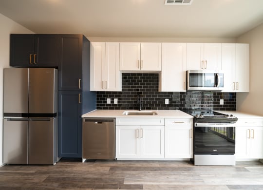 a kitchen with white cabinets and black and white appliances at Abberly Foundry Apartment Homes, Nashville, Tennessee