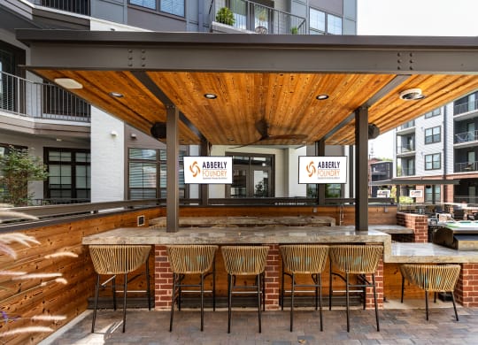 a patio with a bar and a pool in front of a building at Abberly Foundry Apartment Homes, Nashville, Tennessee