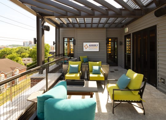 a patio with yellow and blue couches and chairs at Abberly Foundry Apartment Homes, Nashville, TN