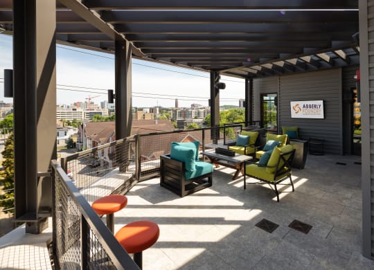 a patio with chairs and a table on top of a buildingat Abberly Foundry Apartment Homes, Nashville, TN