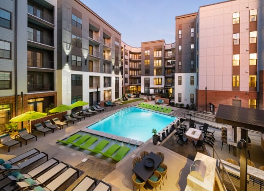 an outdoor pool with lounge chairs and umbrellas at the bradley braddock road at Abberly Foundry Apartment Homes, Nashville, Tennessee