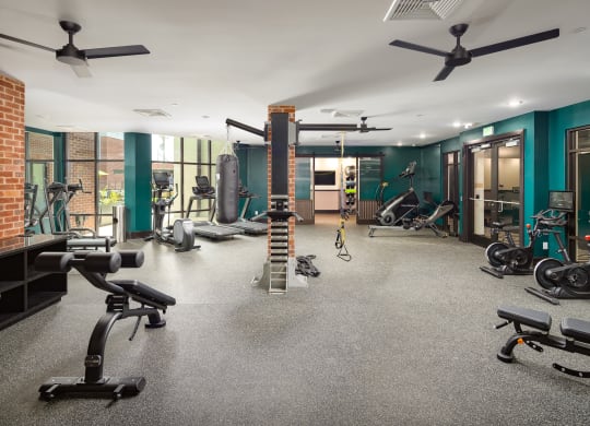 a large fitness room with exercise equipment and green wallsat Abberly Foundry Apartment Homes, Nashville, TN