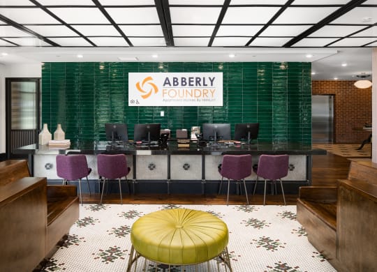 a view of the abbey foundry reception desk with purple and green chairs and a yellowat Abberly Foundry Apartment Homes, Nashville