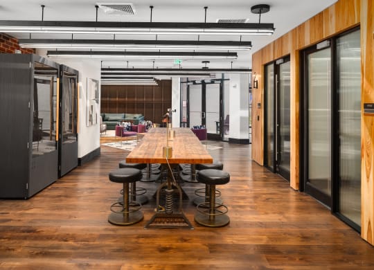 a conference room with a long wooden table and black stools at Abberly Foundry Apartment Homes, Nashville, TN