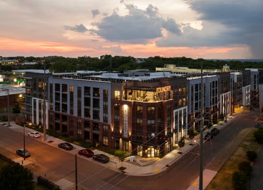 an aerial view of a large building with a sunset in the background at Abberly Foundry Apartment Homes, Nashville, TN