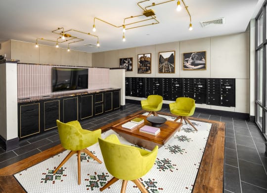 a living room filled with yellow chairs and a wooden tableat Abberly Foundry Apartment Homes, Nashville, TN, 37206