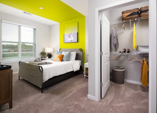 a bedroom with a green accent wall and gray carpet  at Abberly Noda Vista Apartment Homes, Charlotte, NC, 28206