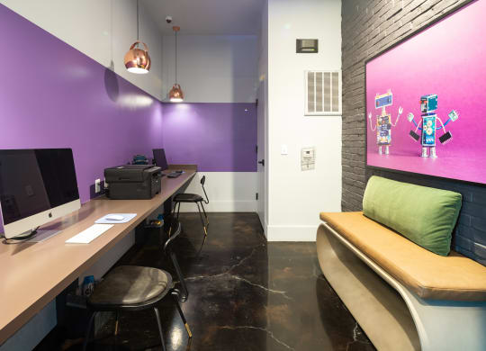 a workspace with two computers and a bench with a green pillow at Abberly Noda Vista Apartment Homes, Charlotte, NC, 28206