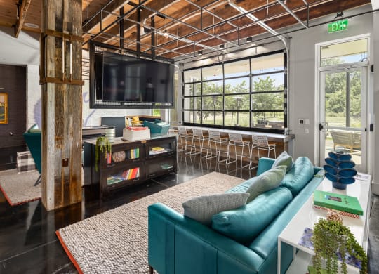 a living room filled with furniture and a large window  at Abberly Noda Vista Apartment Homes, Charlotte