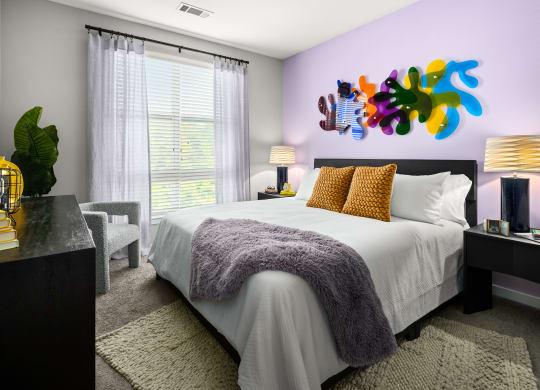a bedroom with a large bed and a colorful painting on the wall  at Abberly Noda Vista Apartment Homes, Charlotte