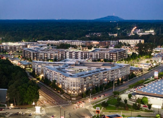 a city at night with a mountain in the background at Abberly Onyx Apartment Homes, Decatur, GA
