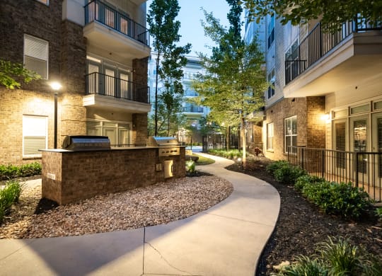 a pathway leading to an apartment complex with trees and bushes  at Abberly Onyx Apartment Homes, Decatur, GA