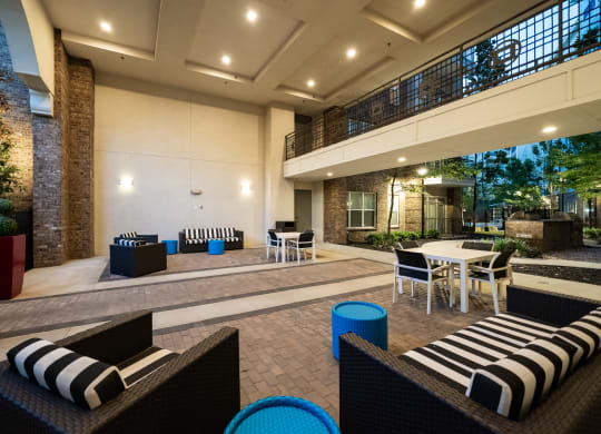 a lounge area with tables and chairs and a fire pit in the background  at Abberly Onyx Apartment Homes, Decatur, 30033