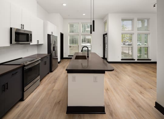 a kitchen with white cabinets and black countertops at Abberly Riverwalk Apartment Homes, Nashville