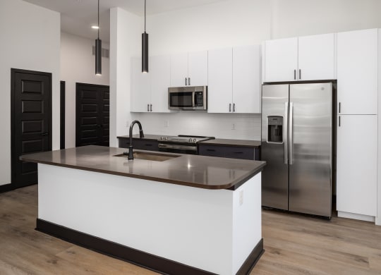 a kitchen with white cabinets and a large island at Abberly Riverwalk Apartment Homes, Tennessee
