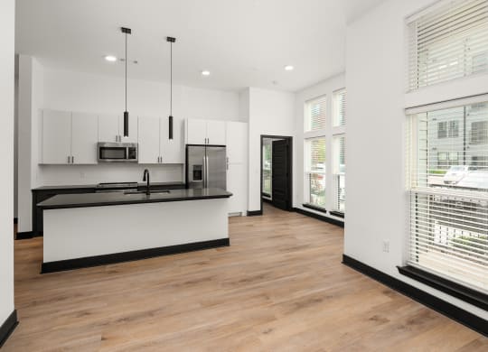 a kitchen and living room with white walls and hardwood floors at Abberly Riverwalk Apartment Homes, Nashville, Tennessee