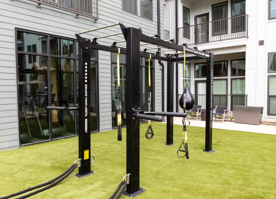 a piece of exercise equipment in the middle of a grassy area in front of a building at Abberly Riverwalk Apartment Homes, Tennessee