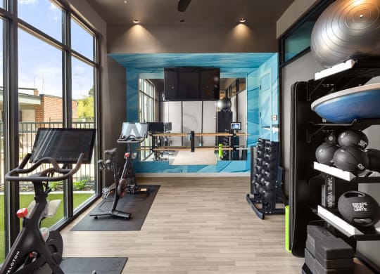 a home gym with a blue accent wall and wood flooring at Abberly Riverwalk Apartment Homes, Nashville, TN
