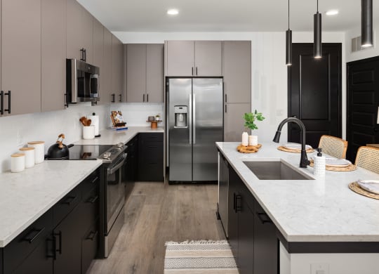 a kitchen with dark cabinets and white countertops  at Abberly Riverwalk Apartment Homes, Tennessee, 37228
