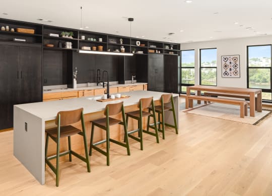 a large kitchen with a large center island with a marble countertop and a wooden dining table  at Abberly Riverwalk Apartment Homes, Nashville, TN