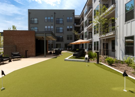 a courtyard with synthetic grass and umbrellas at Abberly Riverwalk Apartment Homes, Tennessee