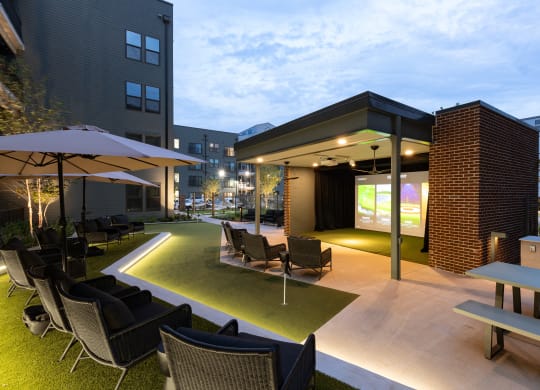 an outdoor lounge area with tables and chairs and a projector screen at Abberly Riverwalk Apartment Homes, Nashville, TN