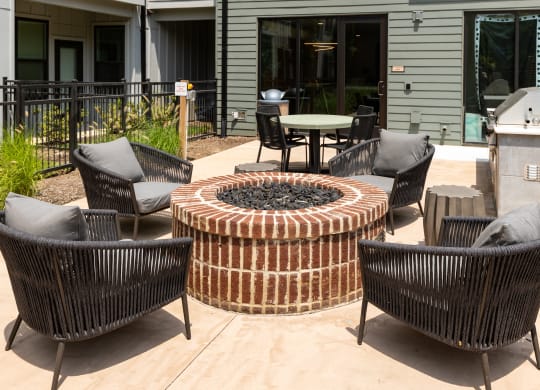 an outdoor patio with a firepit and wicker chairs at Abberly Riverwalk Apartment Homes, Nashville, TN, 37228