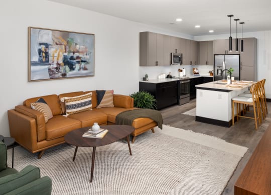 a living room with a couch coffee table and a kitchen in the background  at Abberly Riverwalk Apartment Homes, Nashville, 37228
