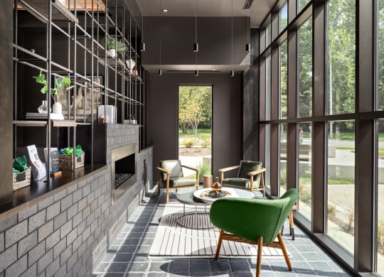 a living room with a fireplace and large windows at Abberly Riverwalk Apartment Homes, Tennessee