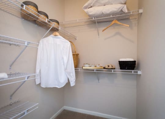 a walk in closet with a white shirt on a hanger at Abberly Grove Apartment Homes, North Carolina, 27610