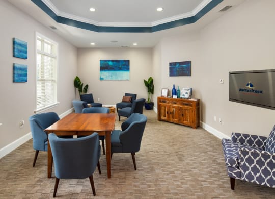 a conference room with a table and chairs and a television