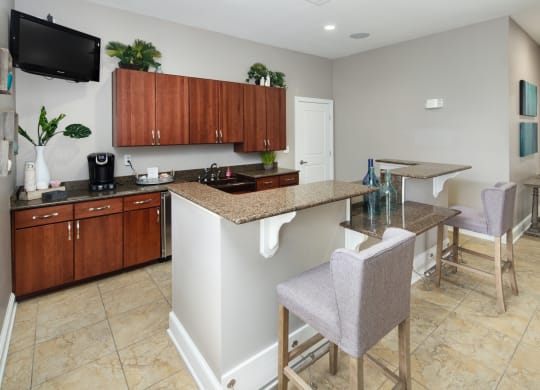 a kitchen with a bar and a dining area with chairs
