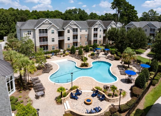 an aerial view of a swimming pool with apartments in the background