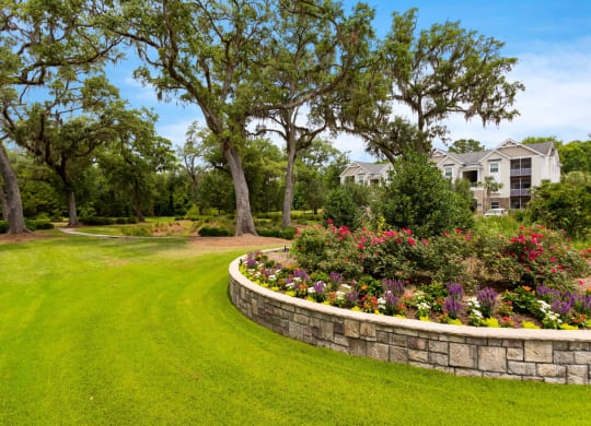 a garden with a stone retaining wall and flowers