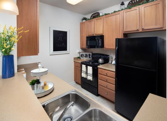 a kitchen with black appliances and wooden cabinets and a counter top