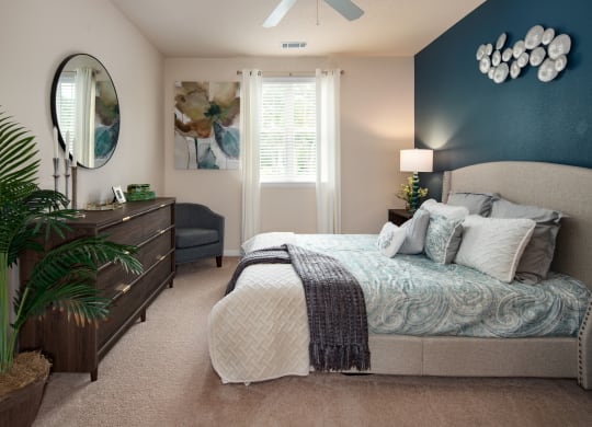 a bedroom with a large bed and a blue accent wall