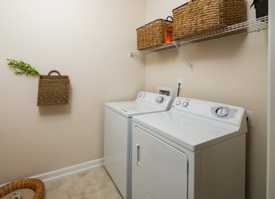 a washer and dryer in a laundry room with a basket on the wall