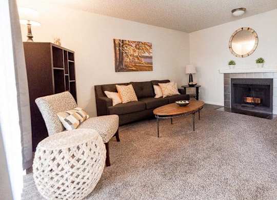 A living room with a fireplace and a grey couch at Altitude Apartment , Tacoma, WA
